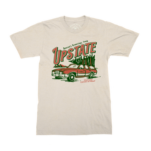A photo of Upstate of Mind limited edition tee of the month: Season's Greetings Tee. Featuring a red station wagon hauling a Christmas tree. "Find your Upstate of Mind!"