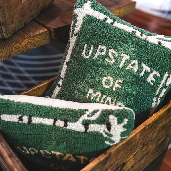 Upstate of Mind Handmade Hooked Wool Decor Pillows in a wooden crate inside the Upstate of Mind flagship store.