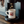 Load image into Gallery viewer, A lifestyle photo of The Woody Wagon Ceramic Mug. White background, the mug is a light creme, tan color, and the graphic is burgundy with a design of a vintage station wagon in the wood. Text on the mug reads "Upstate of Mind", and is under a Keurig coffee machine.
