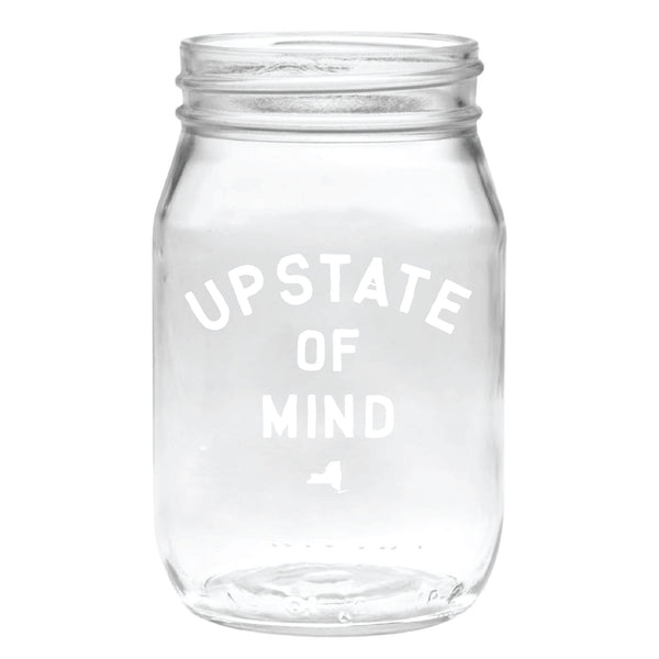 Our popular Upstate of Mind Mason Jar Pint Glass. Clear glass with white text on the front of the mason jar that reads "Upstate of Mind".