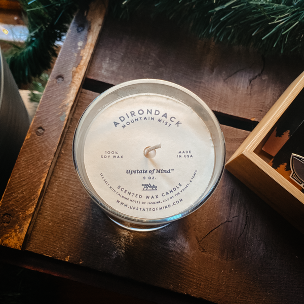 Photo of Adirondack Mountain Mist Candle - 9oz as an overhead shot, on top of a rustic wooden box.