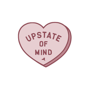 A sticker of a pink heart and "Upstate of Mind" text in the middle. Text is dark pink, as well as the outline of the heart.