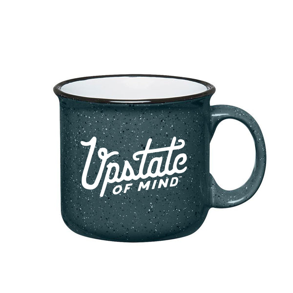 A product photo of our newest ceramic mug in speckled slate gray. White text on the front of the mug reads "Upstate of Mind" and the interior of the mug is white. Black rim around the top of the mug, as well.