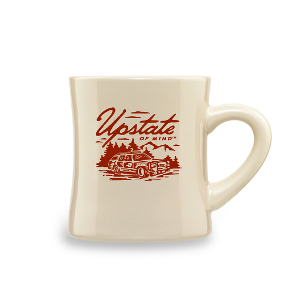 A product photo of The Woody Wagon Ceramic Mug. White background, the mug is a light creme, tan color, and the graphic is burgundy with a design of a vintage station wagon in the wood. Text on the mug reads "Upstate of Mind".