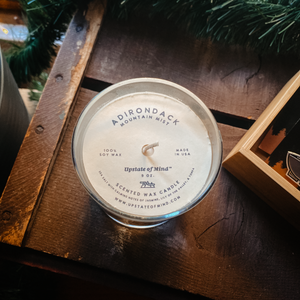 Photo of Adirondack Mountain Mist Candle - 9oz as an overhead shot, on top of a rustic wooden box.