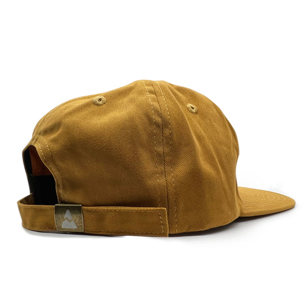 UOM Chain Stitch Cap - Washed Mustard Yellow. Back strap has the Compas Life mountain logo.